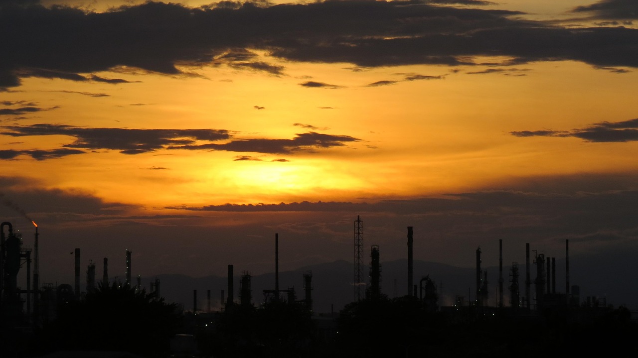 Sunset silhouette over refinery infrastructure