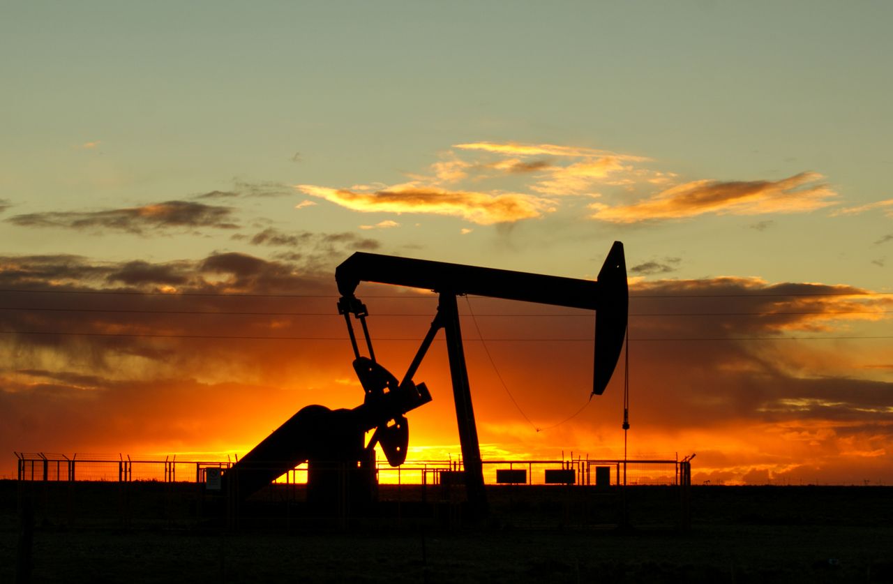 Pump jack silhouetted against a sunset sky